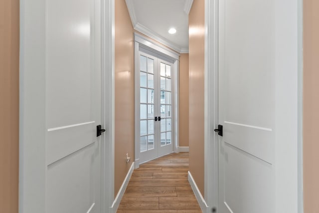 corridor with ornamental molding and light wood-type flooring