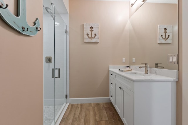 bathroom featuring wood-type flooring, an enclosed shower, and vanity