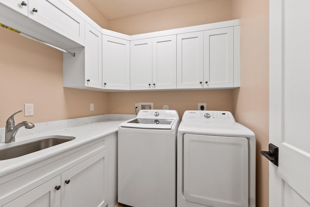 laundry room with cabinets, washer and dryer, and sink