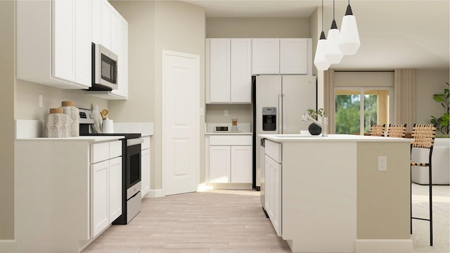 kitchen featuring stainless steel appliances, white cabinetry, pendant lighting, and light wood-type flooring