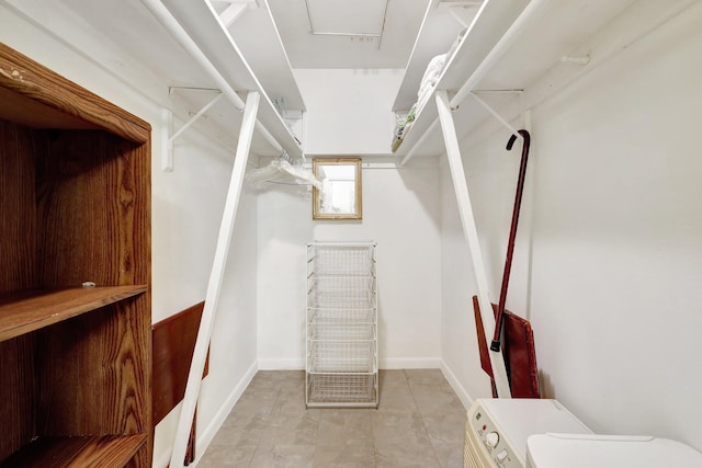 walk in closet featuring washer / dryer and light tile patterned floors