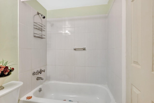 bathroom with toilet and tiled shower / bath combo