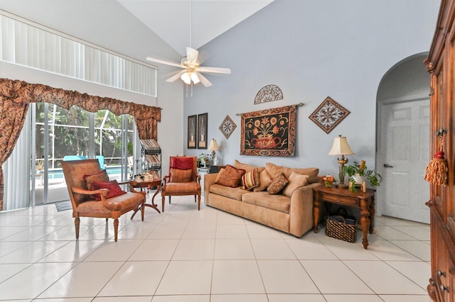 living area featuring high vaulted ceiling, arched walkways, tile patterned flooring, and ceiling fan