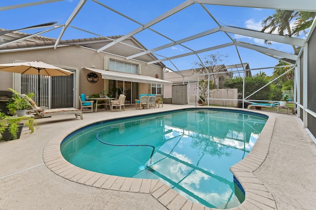 view of pool with a patio and glass enclosure