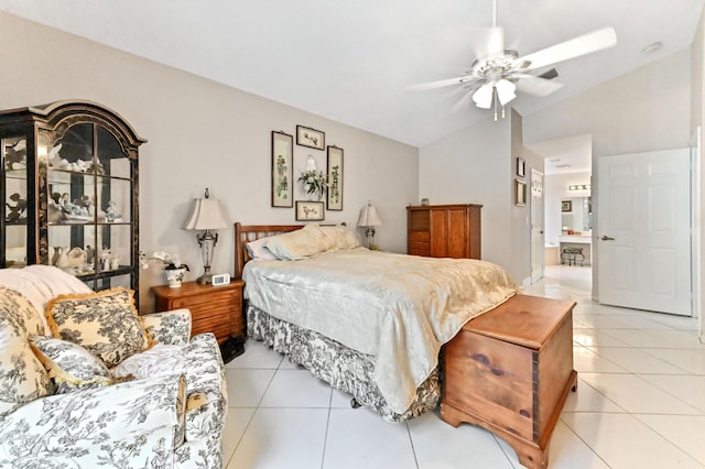 bedroom featuring ceiling fan, light tile patterned flooring, ensuite bath, and vaulted ceiling