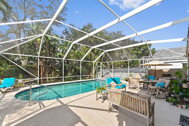 view of pool featuring grilling area, glass enclosure, and a patio area