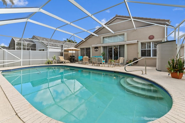 view of swimming pool featuring a patio and glass enclosure