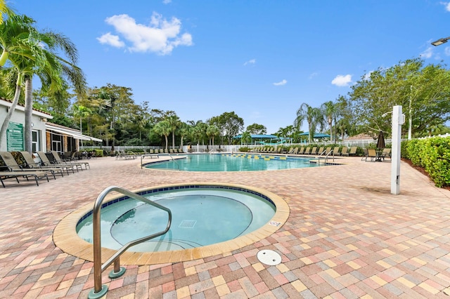 view of swimming pool featuring a patio area and a hot tub