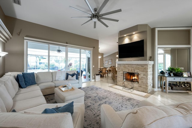 living room featuring light tile patterned flooring, ceiling fan, and a fireplace