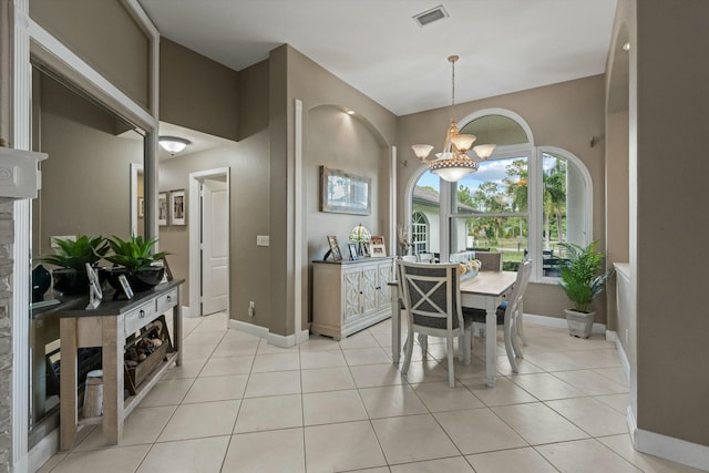 tiled dining area featuring a chandelier