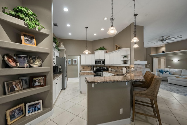 kitchen with sink, white cabinetry, hanging light fixtures, kitchen peninsula, and stainless steel appliances