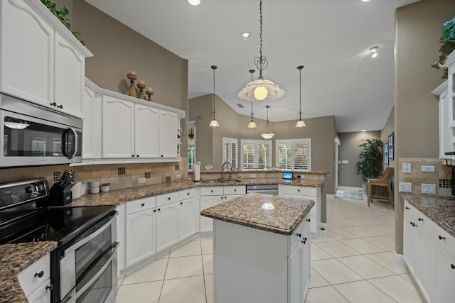 kitchen with sink, kitchen peninsula, a kitchen island, pendant lighting, and stainless steel appliances