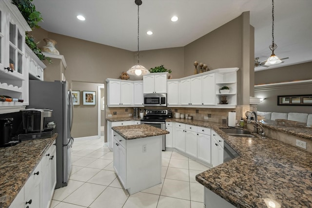 kitchen featuring hanging light fixtures, stainless steel appliances, sink, and a kitchen island