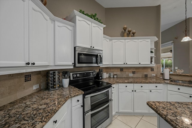 kitchen featuring white cabinetry, hanging light fixtures, light tile patterned floors, appliances with stainless steel finishes, and backsplash