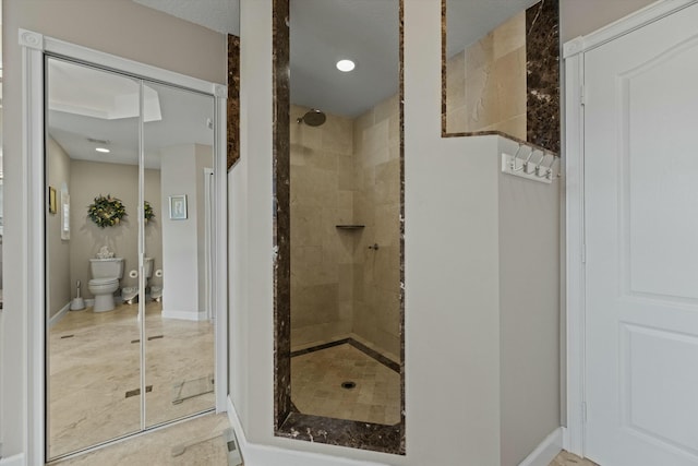 bathroom with tiled shower and toilet