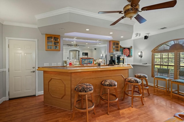 bar with crown molding, hardwood / wood-style floors, and ceiling fan