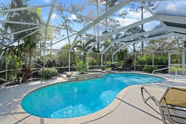 view of swimming pool featuring pool water feature, a patio, a lanai, and an in ground hot tub