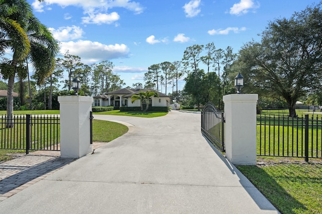 view of gate with a lawn