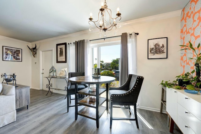 dining area with crown molding, wood-type flooring, and a chandelier