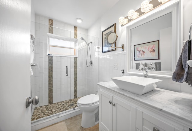 bathroom featuring toilet, an enclosed shower, tile walls, vanity, and tile patterned flooring