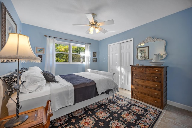 tiled bedroom featuring ceiling fan and a closet