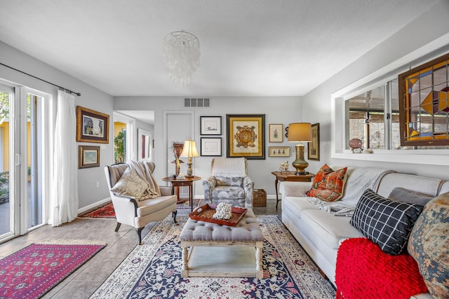 tiled living room featuring an inviting chandelier