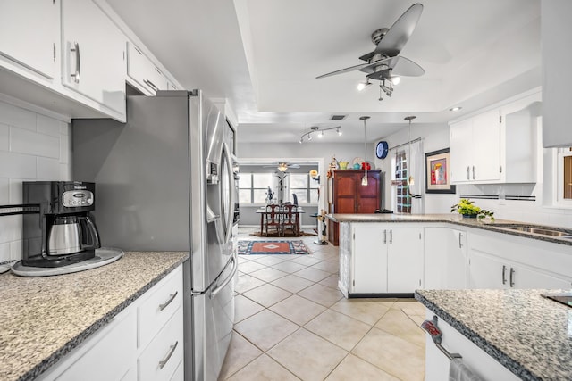 kitchen with white cabinetry, light tile patterned flooring, backsplash, and ceiling fan