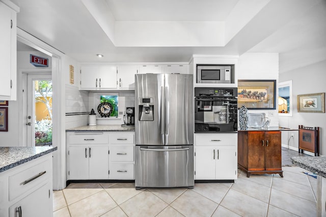 kitchen with light tile patterned flooring, tasteful backsplash, white cabinetry, stainless steel appliances, and light stone countertops