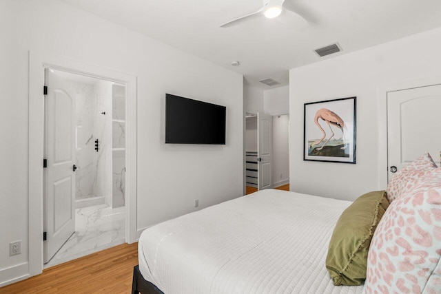 bedroom with hardwood / wood-style flooring, ensuite bathroom, and ceiling fan