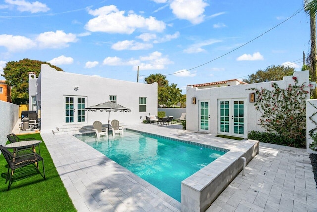 view of pool with a patio, an outdoor structure, and french doors