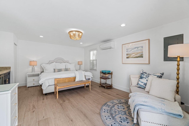 bedroom with a wall mounted air conditioner and light wood-type flooring