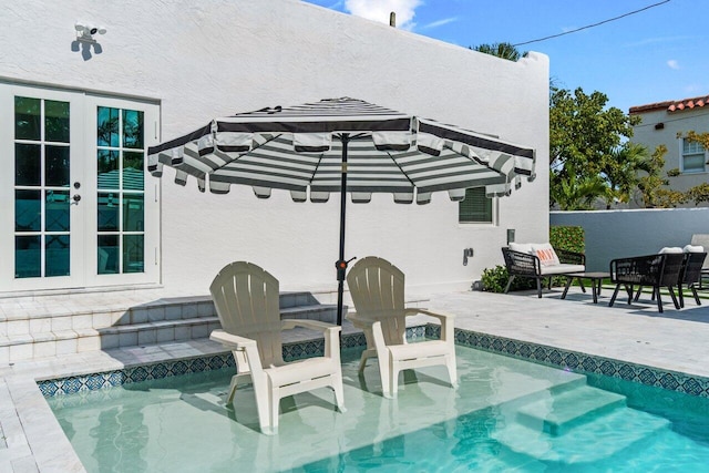 view of pool featuring a patio and french doors