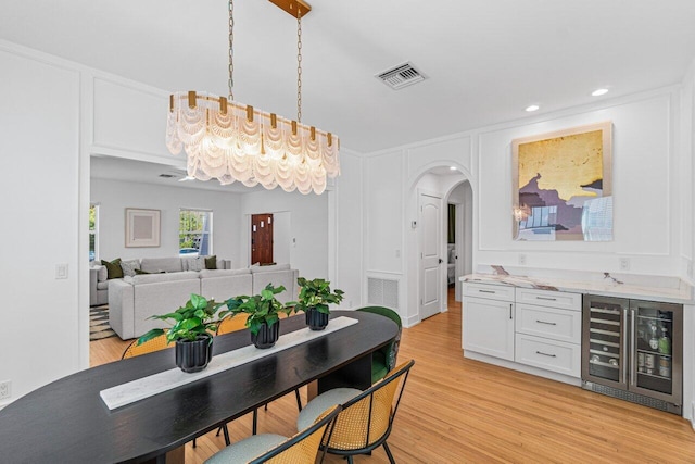 dining area featuring wine cooler and light hardwood / wood-style flooring