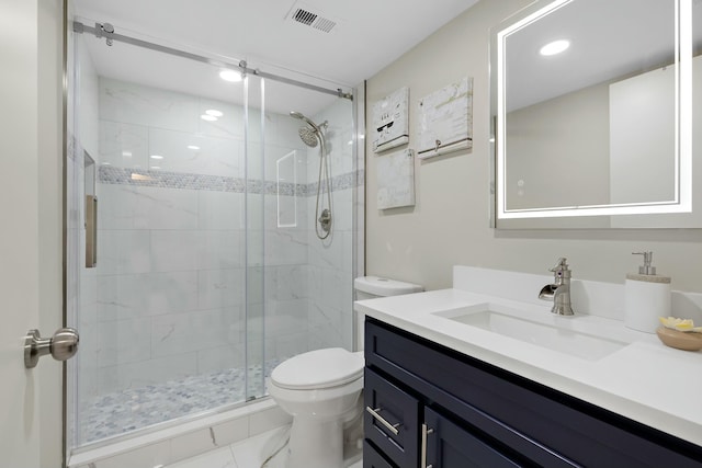 bathroom with a shower with door, vanity, and toilet