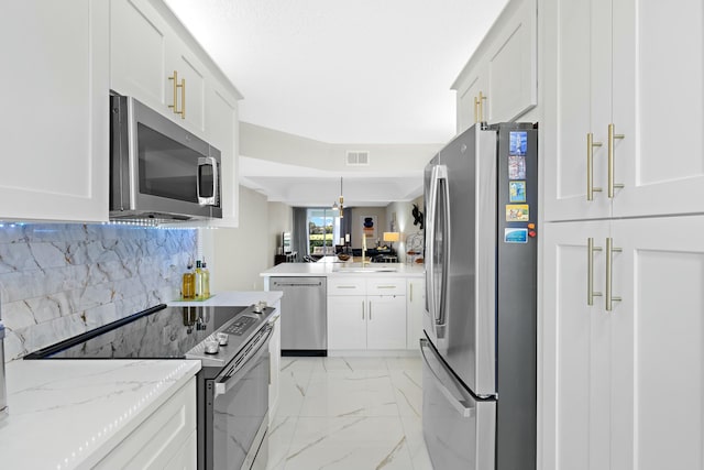 kitchen with stainless steel appliances, white cabinetry, tasteful backsplash, and light stone counters