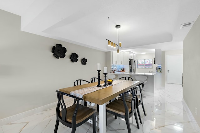 dining area with a raised ceiling