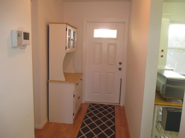 doorway featuring light wood-type flooring and baseboards