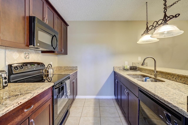 kitchen with sink, tasteful backsplash, light tile patterned floors, pendant lighting, and black appliances