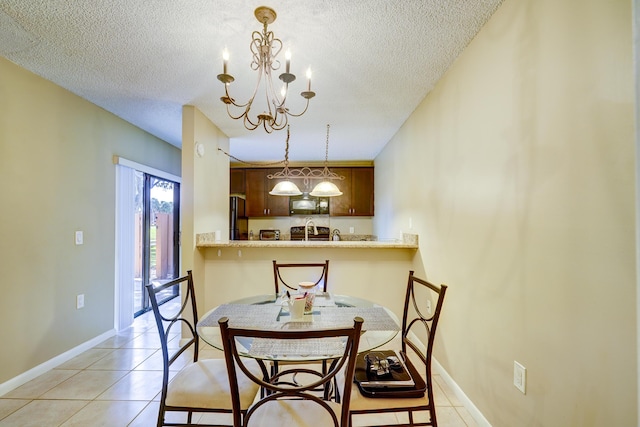 dining space featuring a chandelier, a textured ceiling, and light tile patterned floors