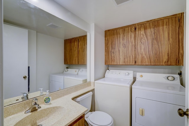 laundry area with separate washer and dryer and sink