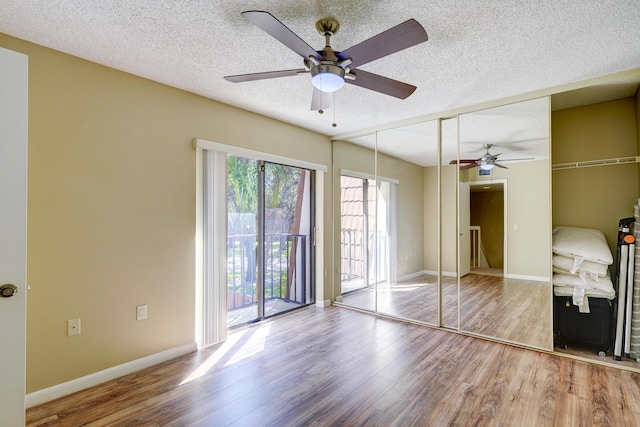 unfurnished bedroom with access to exterior, light hardwood / wood-style flooring, and a textured ceiling