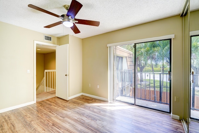 spare room with ceiling fan, light hardwood / wood-style floors, and a textured ceiling