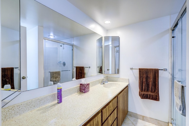 bathroom with vanity, a shower with shower door, and tile patterned flooring