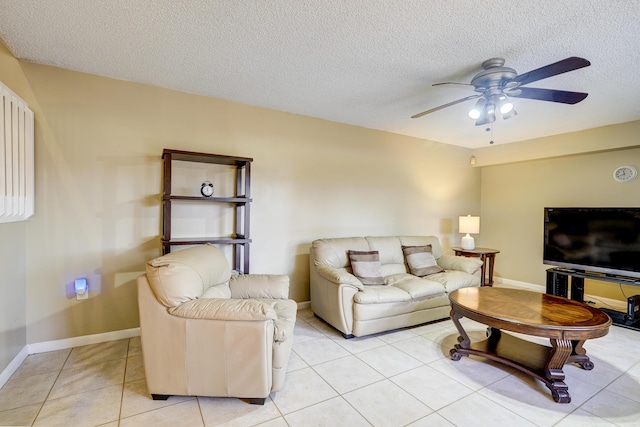 living room featuring ceiling fan, light tile patterned floors, and a textured ceiling