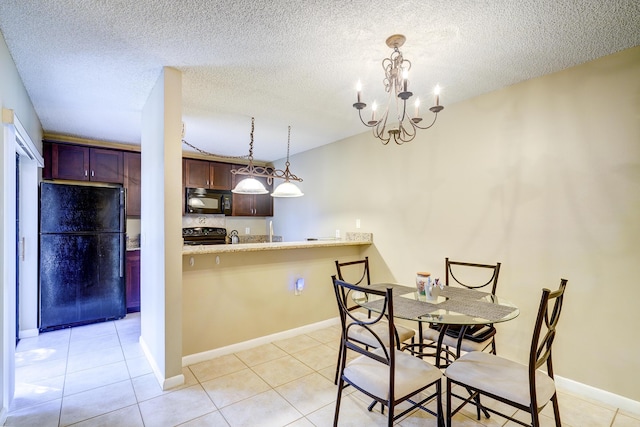 tiled dining room with an inviting chandelier and a textured ceiling