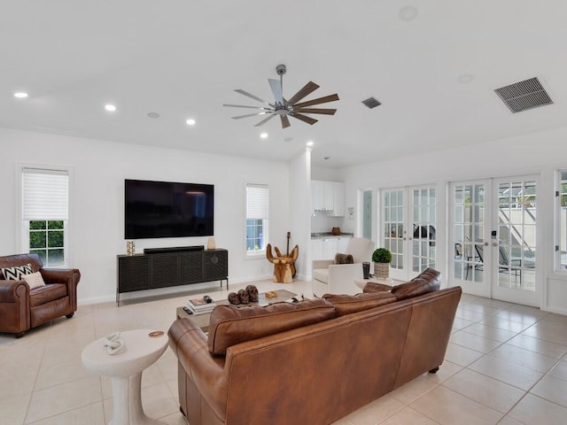 living room with french doors, ceiling fan, and light tile patterned floors