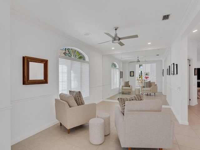 living room with light tile patterned floors, crown molding, and ceiling fan