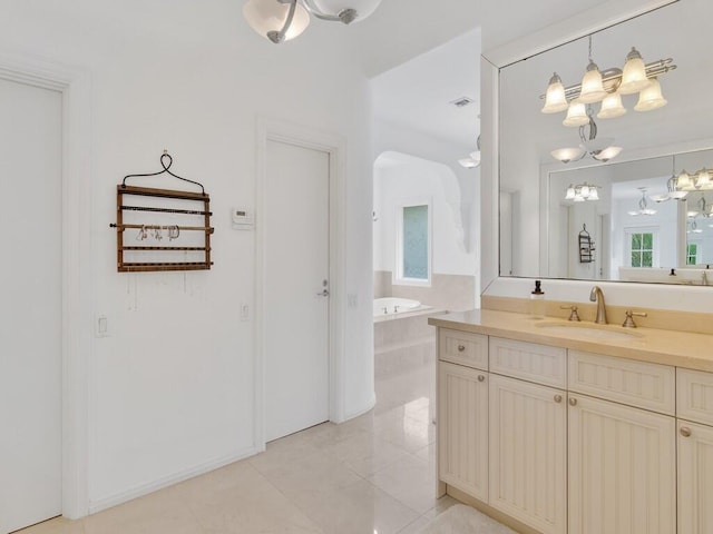 bathroom featuring tile patterned flooring, vanity, and a relaxing tiled tub