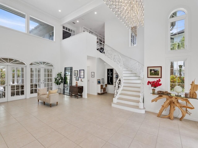 foyer entrance featuring a high ceiling, french doors, a chandelier, and light tile patterned flooring