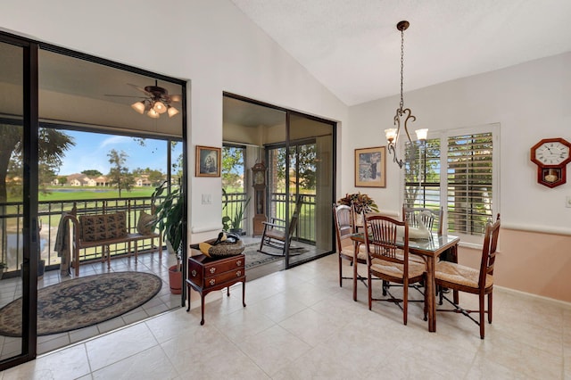 dining space featuring ceiling fan with notable chandelier, a wealth of natural light, and high vaulted ceiling